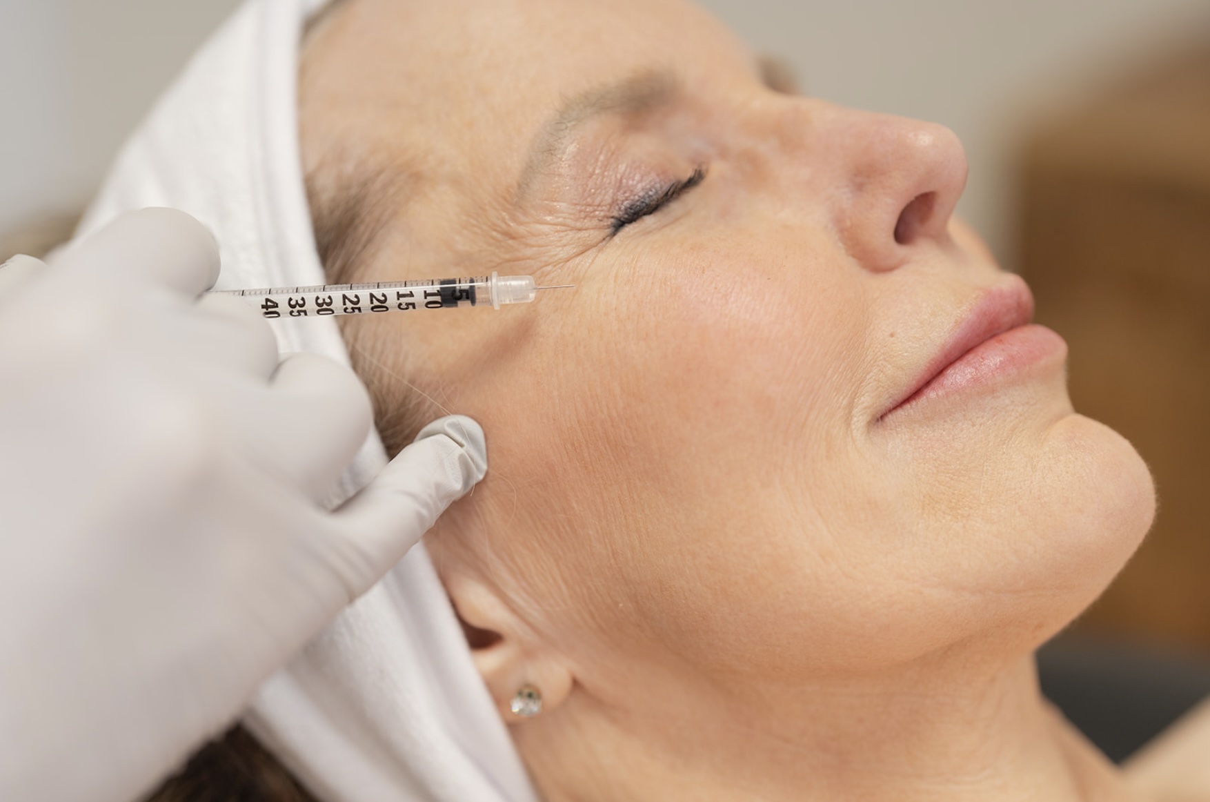 Woman receiving injectable treatment of Botox and filler.